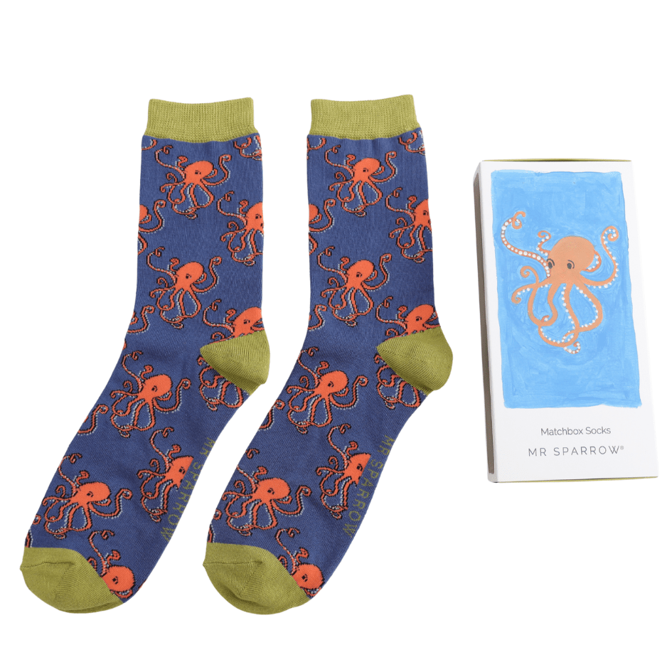 The octopus socks laid beside the small, matchbox style box
