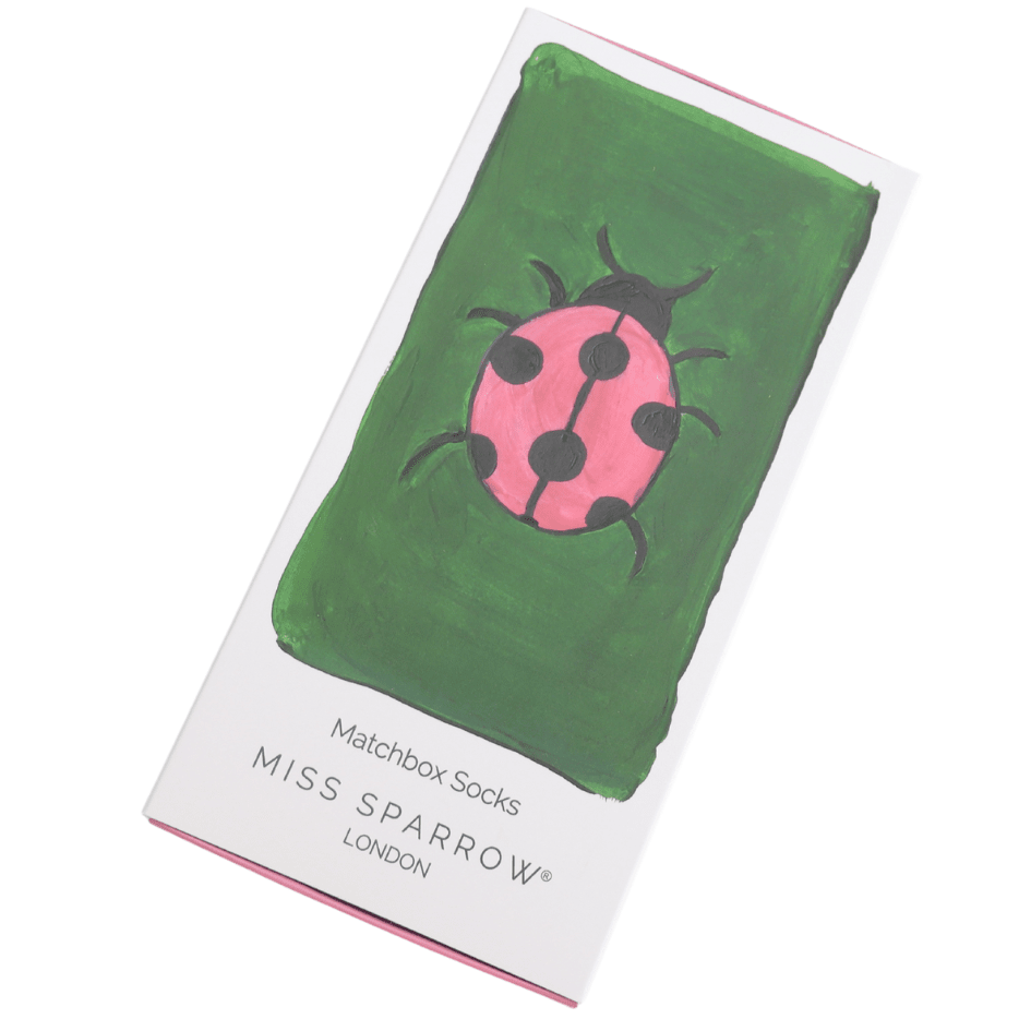 Miss Sprrow London matchbox socks in white packaging with a green and pink ladybird illustration on the front.