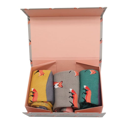 Three pairs of socks in yellow, gray, and green with fox patterns in a gift box.