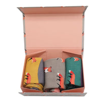 Load image into Gallery viewer, Three pairs of socks in yellow, gray, and green with fox patterns in a gift box.