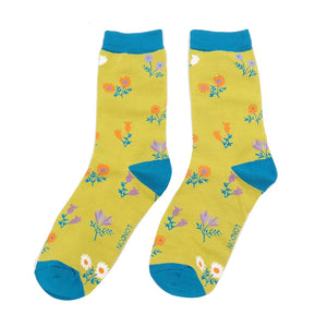 pair of yellow bamboo socks with dainty floral design and blue trim 