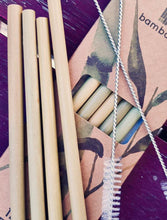 Load image into Gallery viewer, 4 bamboo straws and 2 cleaning brushes arranged on top of the box they are packed in, with more straws still inside