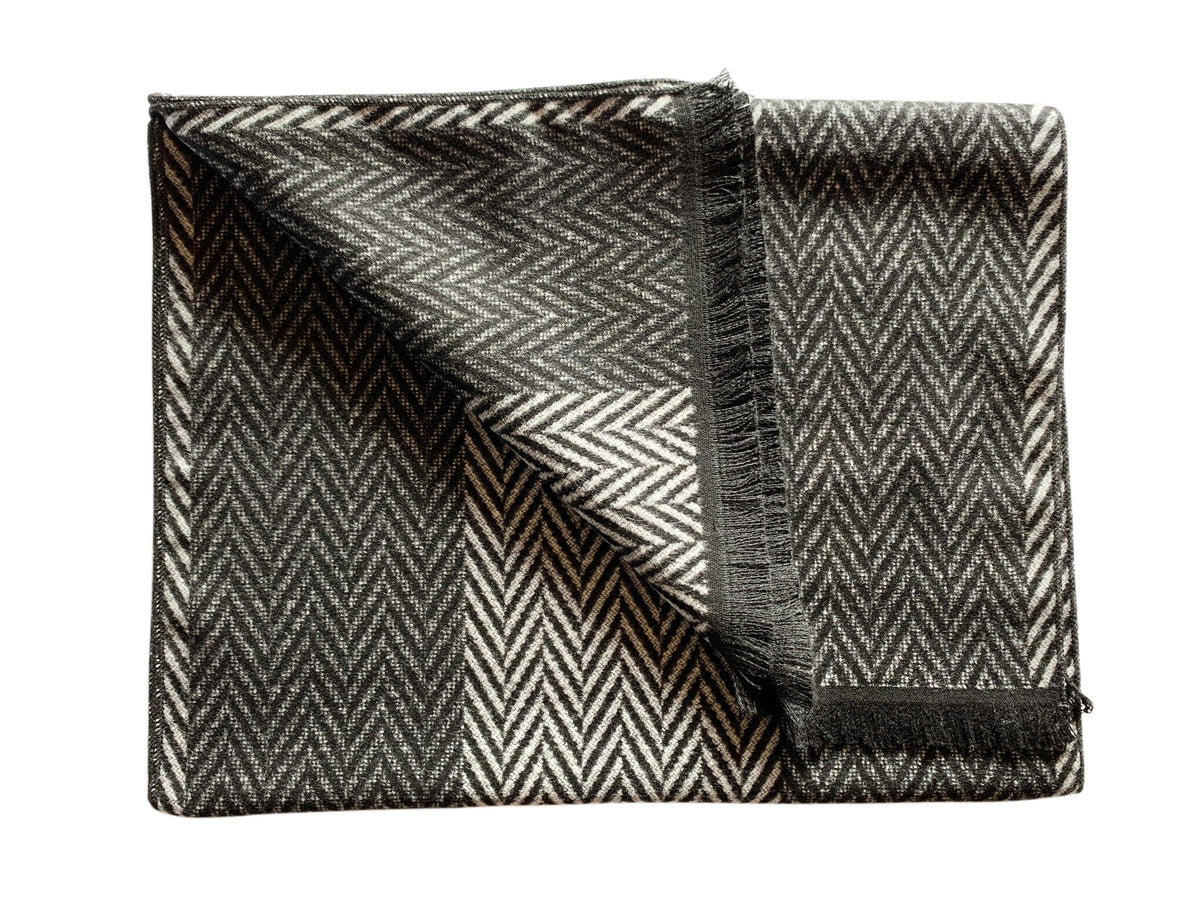 A Black and white scarf with a tassled edge and a herringbone design